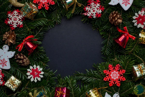 Christmas wreath decorated with decorative snowflakes and toys on a black background