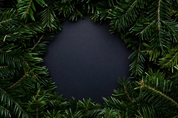 Wreath of Christmas tree branches with a black place for text in the middle