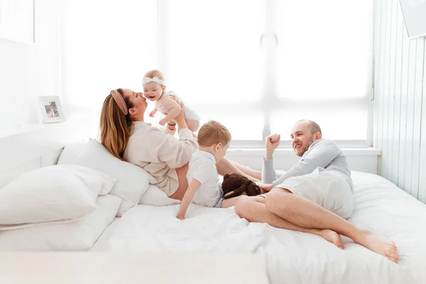 Een Jong Gelukkig Gezin Met Jonge Kinderen Liggend Knuffelend Lachend — Stockfoto