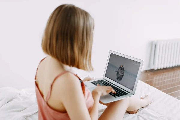 Pembe pijamalı, dizüstü bilgisayarlı, evde, internette, iş yerinde, yatakta uzanan, telefonla konuşan, sipariş, dükkan, parlak iç mekan.