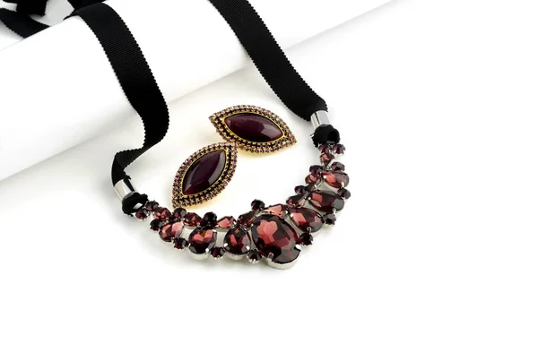 Collana di vetro viola e orecchini su sfondo bianco Immagini Stock Royalty Free