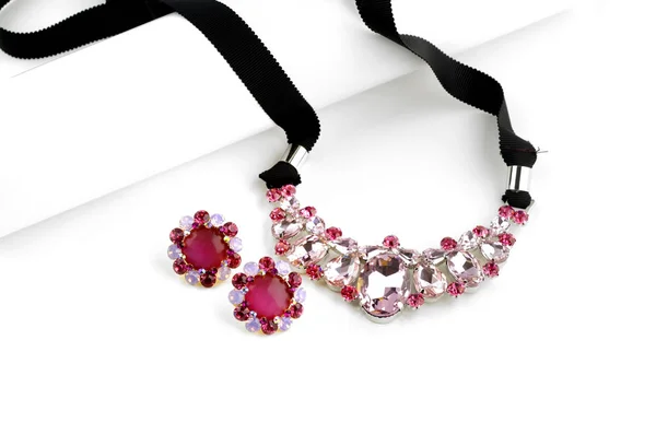 Ожерелье из розового стекла и серьги на белом фоне — стоковое фото