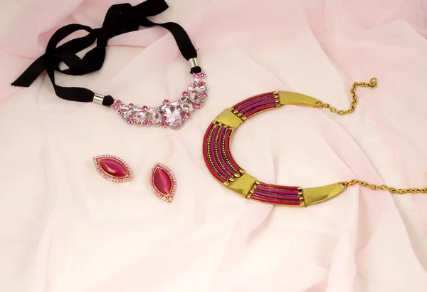 Fashion jewelry advertisement - bijouterie on pink kerchief — Stock Photo, Image