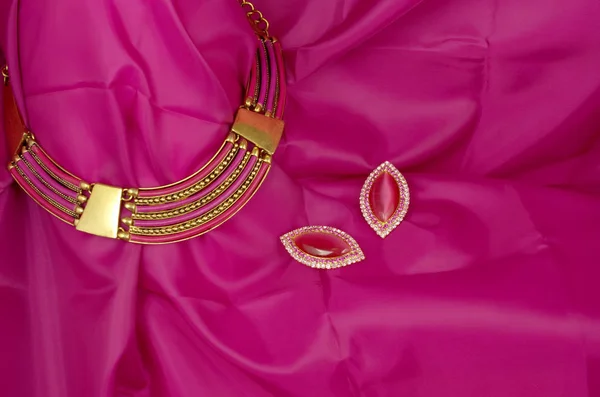 Collar rosa brillante sobre fondo textil rosa - joyería de moda rojiza — Foto de Stock