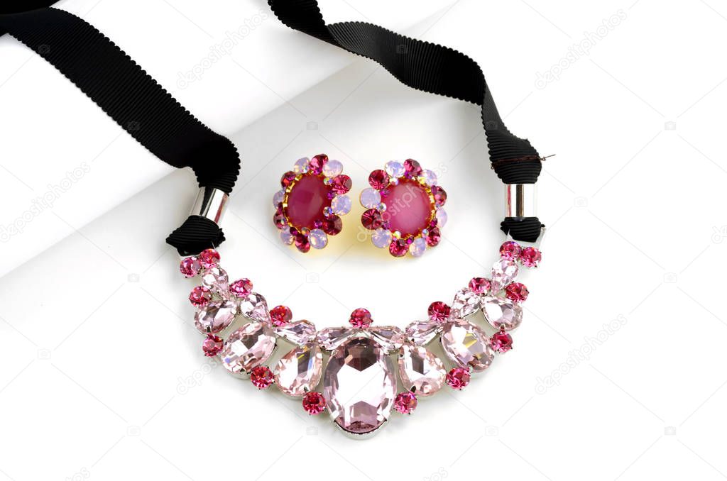 Pink glass necklace and earrings on white background
