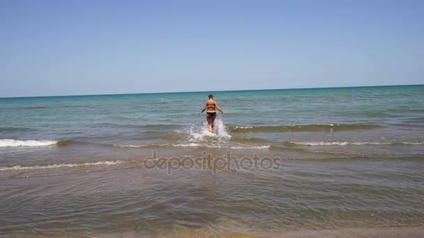 Vrij atletisch meisje model komt uit de zee, langzaam. in een blauwe badpak, — Stockvideo