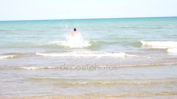 Dziewczyna dość lekkoatletycznego model pochodzi z morza, powoli. w niebieski strój kąpielowy, — Wideo stockowe
