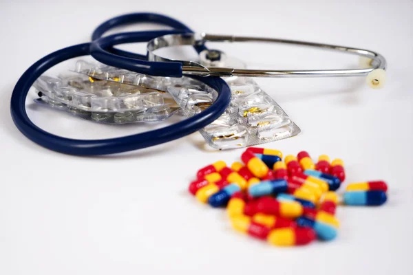 Stetoscopio e medicinali in capsule colorate diverse — Foto Stock