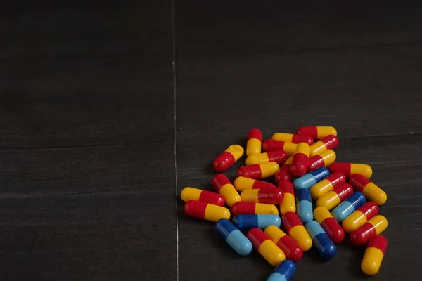 Различные цветные лекарства и типы таблеток на черном фоне . — стоковое фото