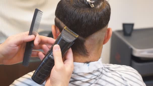 Närbild av män frisyr med clipper i barbershop. Frisyr män Barbershop. Män frisörer. Frisör klipper klientdatorn för hårklippning. — Stockvideo