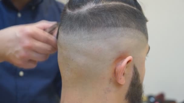 Close up de homens corte de cabelo com cortador de cabelo na barbearia. Homens Cabeleireiros. Barbeiro corta a máquina do cliente para cortes de cabelo . — Vídeo de Stock