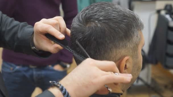 Homem recebendo um corte de cabelo por um cabeleireiro. — Vídeo de Stock