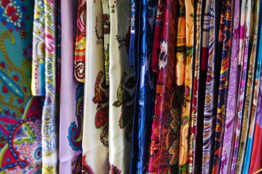 Oriental, Turkish, Indian multi-colored women's silk headscarves handmade on shop window for sale.