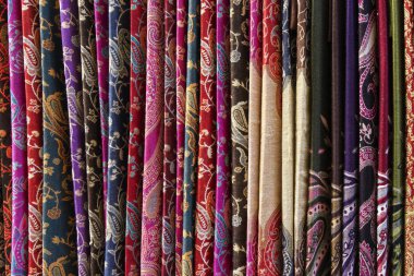 Oriental, Turkish, Indian multi-colored women's silk headscarves handmade on shop window for sale.