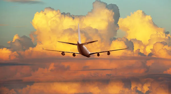 Flugzeug fliegt über dramatischen Wolken bei Sonnenuntergang, Sonnenaufgang. — Stockfoto