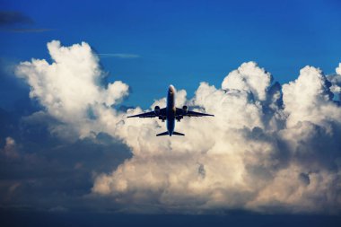 Yolcu uçağı uçuyor. Uçaklar bulutların üzerinde mavi gökyüzünde yükseklerde uçarlar. Uçağın yan görüntüsü