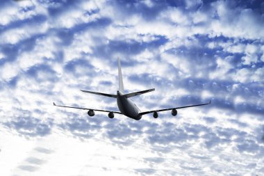 Yolcu uçağı uçuyor. Uçaklar bulutların üzerinde mavi gökyüzünde yükseklerde uçarlar. Uçağın yan görüntüsü