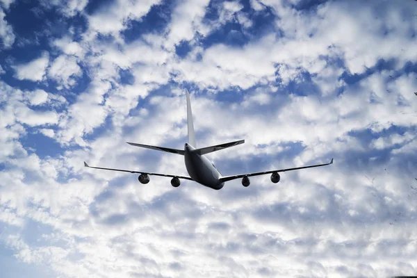 Passagierflugzeug im Flug. Flugzeuge fliegen hoch in den blauen Himmel über den Wolken. Seitenansicht des Flugzeugs — Stockfoto