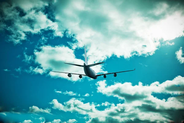 Passagierflugzeug im Flug. Flugzeuge fliegen hoch in den blauen Himmel über den Wolken. Seitenansicht des Flugzeugs — Stockfoto