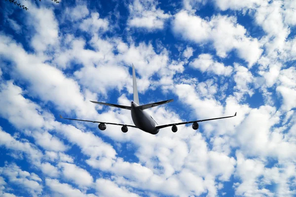 Passagierflugzeug im Flug. Flugzeuge fliegen hoch in den blauen Himmel über den Wolken. Seitenansicht des Flugzeugs — Stockfoto