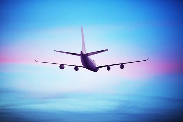 Yolcu uçağı uçuyor. Uçaklar bulutların üzerinde mavi gökyüzünde yükseklerde uçarlar. Uçağın yan görüntüsü — Stok fotoğraf