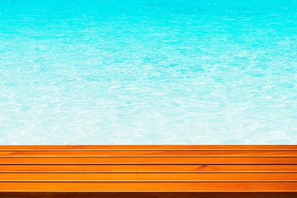 Brązowy drewniany stół przeciwko tropikalnej letniej plaży i fala morska przeciwko błękitnemu niebu. — Zdjęcie stockowe