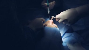 Profesyonel cerrah bir klinikte burun üzerinde zor opeartion yapıyor.