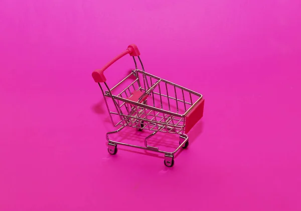 empty shopping cart on pink background. Shopping concept