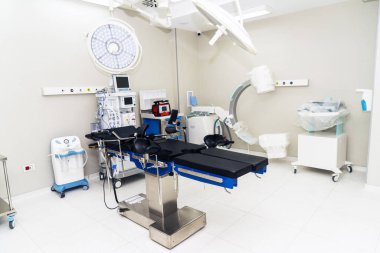 Hastanedeki boş modern ameliyathane. İyi ışıklandırma. Televizyonlu floroskop ve anestezi makinesi