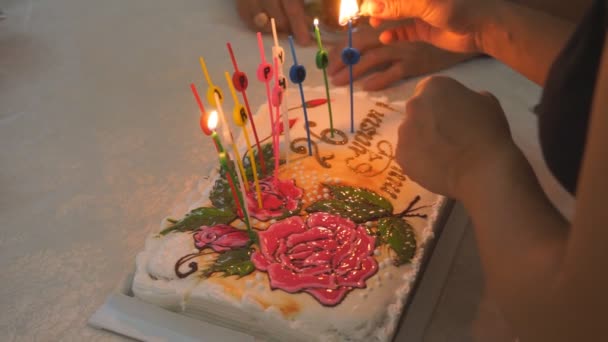 母の手は家で祝う子供の家族のための誕生日ケーキのろうそくを点灯. — ストック動画
