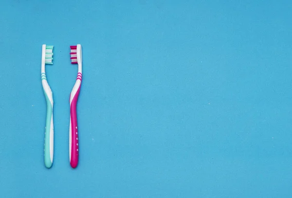 蓝色背景上的蓝色和红色牙刷 更换牙刷的概念 口腔卫生 大家庭和友好的家庭 牙刷的选择 — 图库照片