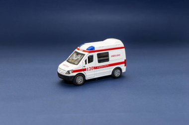Mavi arka planda ambulans oyuncak arabası. Tıbbi bakım ve sağlık kavramı