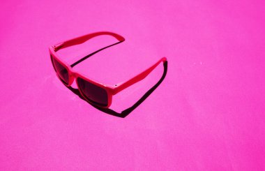 Pastel arka planda pembe güneş gözlüğü deseni var. Minimum yaz konsepti. İzometrik yazdırma.