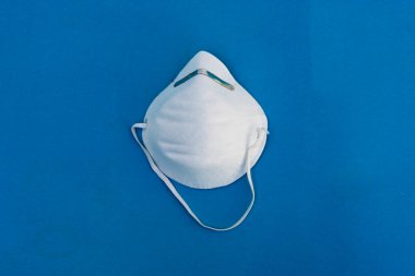 Koronavirüsü önle. Tıbbi maske, tıbbi koruyucu maske mavi arka planda izole edilmiş. Tek kullanımlık yüz maskesi ağız ve burnu kapatır. Sağlık sigortası Coronavirus karantinası, hijyen konsepti