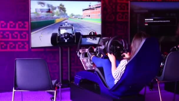 Una chica montando en el simulador de carreras de coches rally — Vídeos de Stock