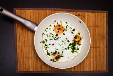 Bir kap sahanda yumurta, kırsal ahşap masa yüzeyinde düdüklü pastırma.