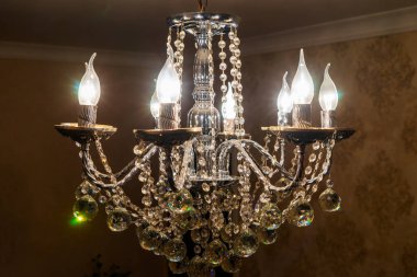 Tavandan sarkan ampullü kristal bir avize..