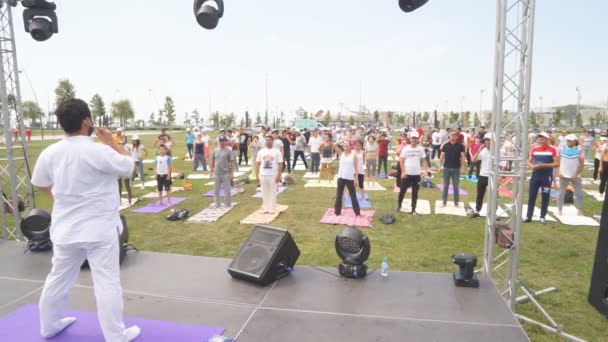 Baku, Ázerbájdžán, 15. května 2017: Kurzy jógy pro muže a ženy během festivalu Den jógy ve velkém stanu na fitness podložkách — Stock video