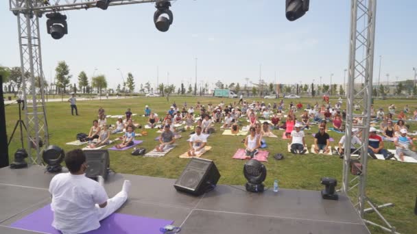 Bakú, Azerbaiyán, 15 de mayo de 2017: Clases de yoga para hombres y mujeres durante el festival Día del yoga en la gran carpa sobre colchonetas de fitness — Vídeos de Stock