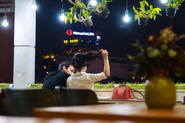 Ho Chi Minh şehri, Vietnam - Aralık 2018: Fener ve yeşil bitkilerle dolu rahat kafenin balkonunda çift kişilik yer.
