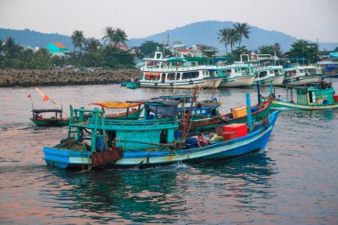 Duong Dong Şehri, Phu Quoc, Vietnam - Aralık 2018: Dalgakıran, bulutlu gökyüzü, palmiye ağaçları ve tepeleri olan deniz kenarı.