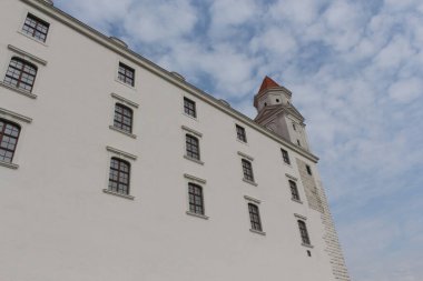 Bratislava, Slovakya - Nisan 2011: Bulutlu gökyüzü, kule ve Bratislava Kalesi 'nin yüksek duvarları.