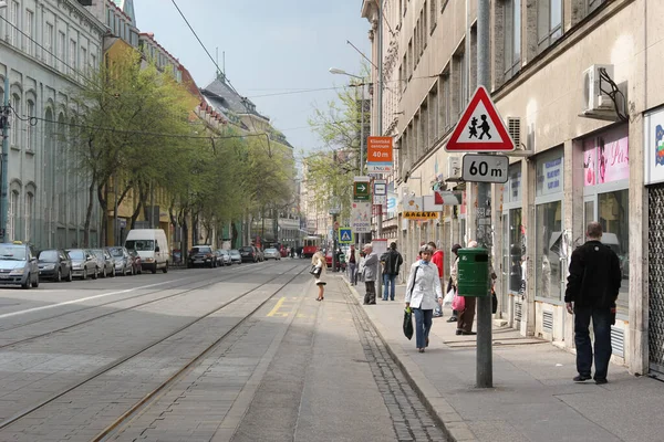 Bratislava, Slovakya - Nisan 2011: Jesenskeho caddesinde tramvay ve demiryolları bekleyen insanlar.