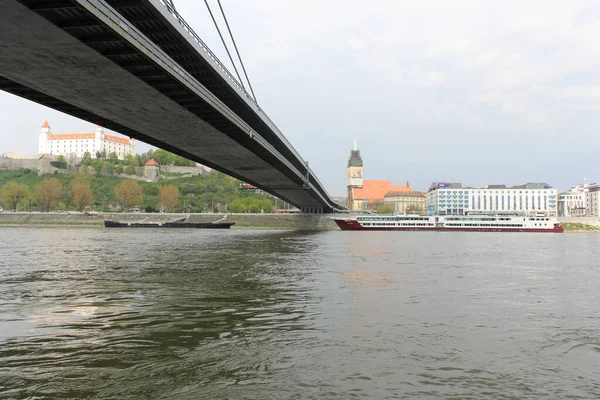 Bratislava, Slovakya - Nisan 2011: Bratislava Kalesi, SNP köprüsü, St. Martin Katedrali ve gemiler Tuna Nehri 'nin karşı kıyısından manzaralı.