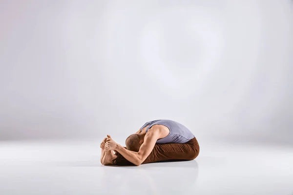 Hombre haciendo yoga aislado sobre fondo blanco — Foto de Stock