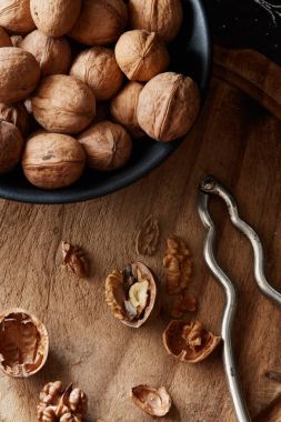 Kırık ceviz ve badem fındık ve Fındıkkıran rustik ahşap yüzeyde bir kase yakın: