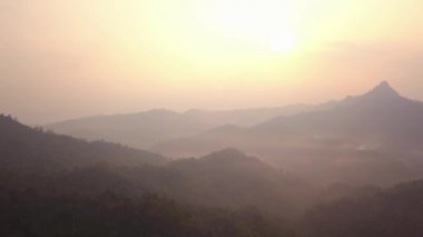 Laos 'ta sabah vahşi orman dağlarının üzerinde güzel bir gündoğumu. Dağların üzerinden uçan hava videosu.