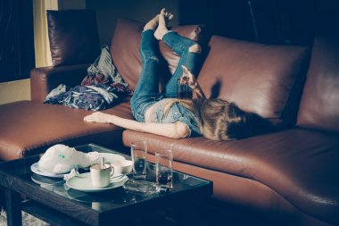 Kanepede yatan genç sarhoş kadın. Depresyon kavramı. Sağlıksız yaşam tarzı.