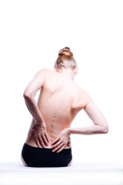 Güzel atletik kadın vücudu. Sırt ağrısı. Şortlu çıplak kadın. Beyaz arka planda izole edilmiş, arka planda stüdyo görüntüsü..