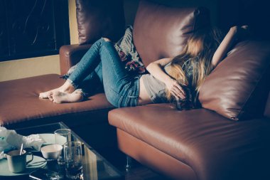 Kanepede yatan genç sarhoş kadın. Depresyon kavramı. Sağlıksız yaşam tarzı.